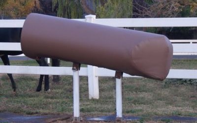 A classic brown SMS stallion breeding phantom mount featuring white dual-leg steel posts installed next to a paddock fence.